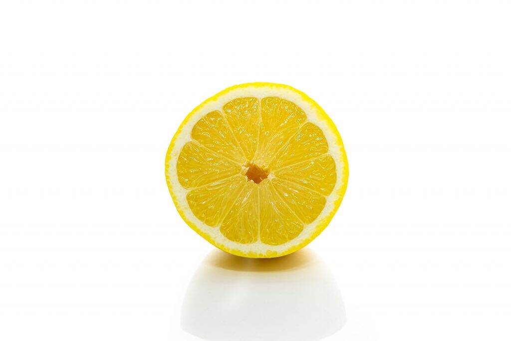 a picture of a lemon on a plain background emphasising using a lemon as a way to clean limescale on your showerhead