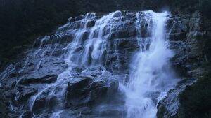 a waterfall with multiple streams flowing down a rock face, suggesting the source of hard water