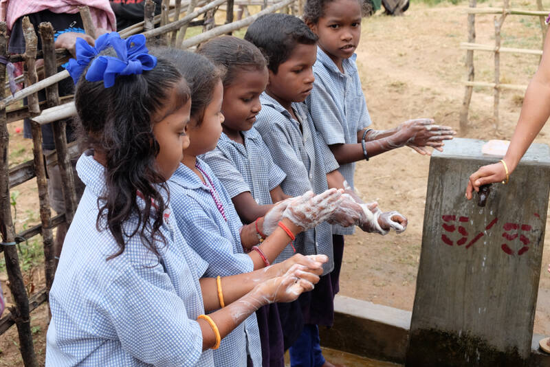 Image of school children washing their hand with water provided by FRANK water