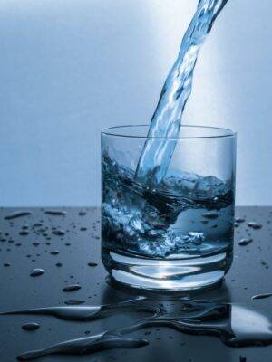 Glass of water being filled implying the health effects of hard water