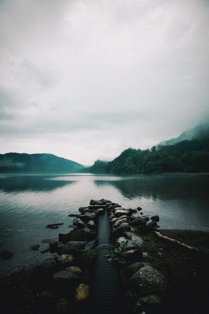 a large pipe entering a reservoir or lake tying into the conversation about a UK water shortage
